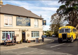photo of the Portland inn pub in gurnard with a vintage single deck yellow bus